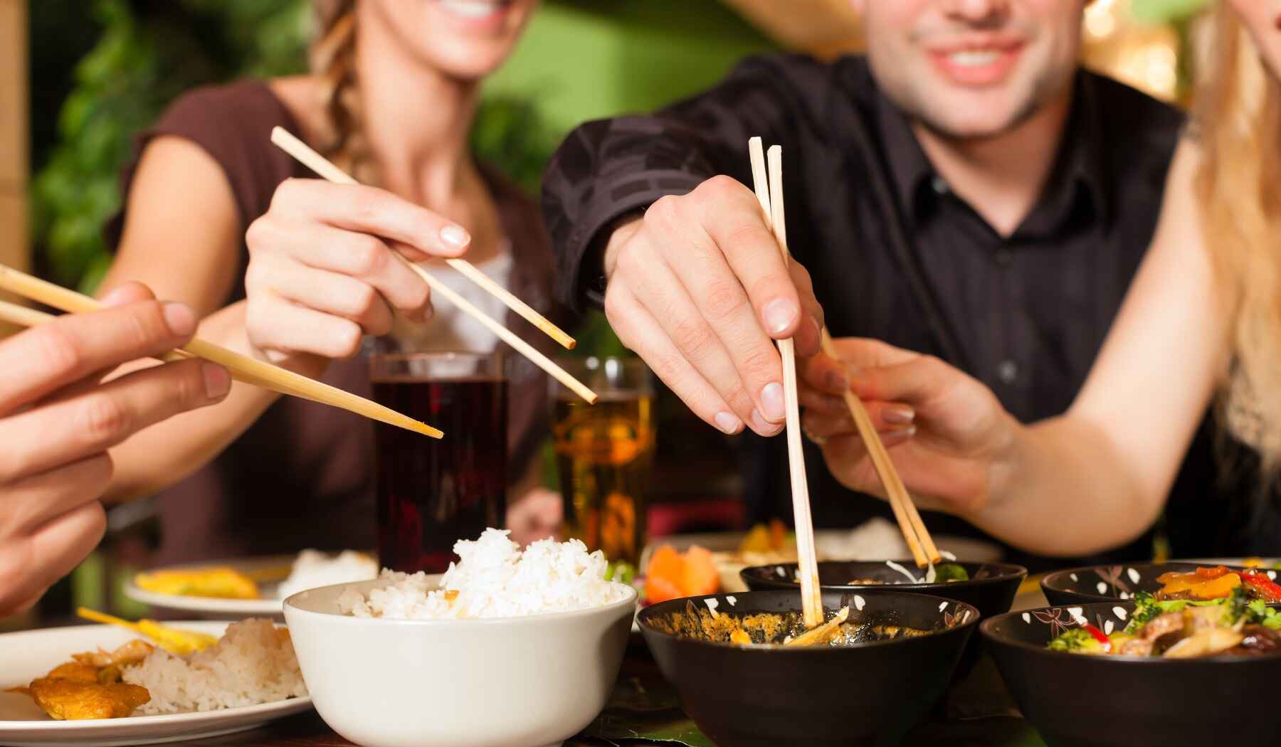 Leute essen mit Stäbchen