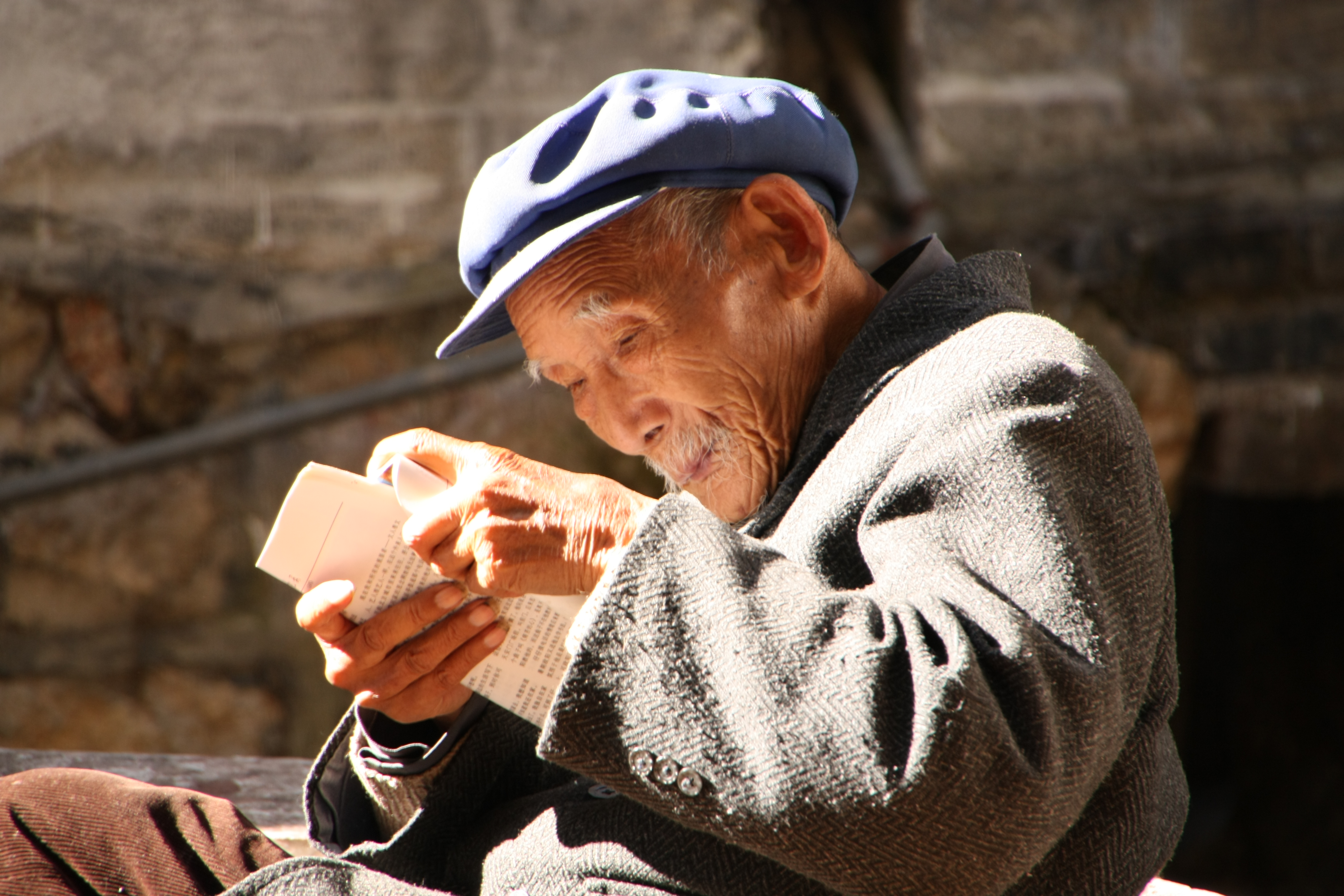 Mann beim Lesen in der Altstadt – Naxi in Lijiang