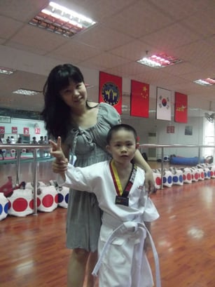 Die Mutter Mendy steht zusammen mit ihren Sohn Bristol in der Taekwondo Schule in Xiamen