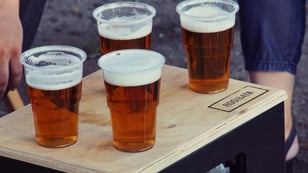 A tray containing beer in disposable cups